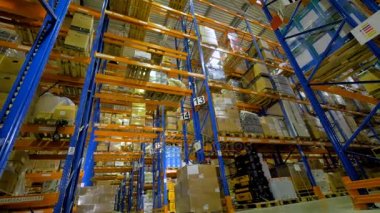 Yüksek raflar üzerinde saklanan kargo ile ahşap palet.