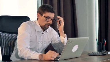 Bir işadamı bir dizüstü bilgisayarda türleri ve sighs.