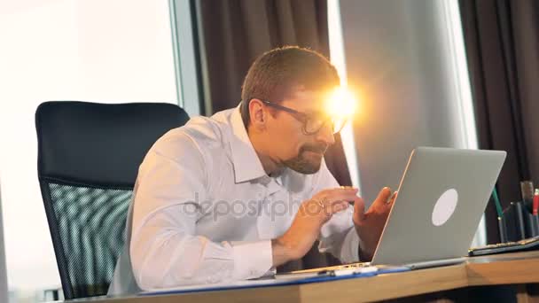 Een zakenman krijgt goed nieuws op zijn laptop scherm. — Stockvideo