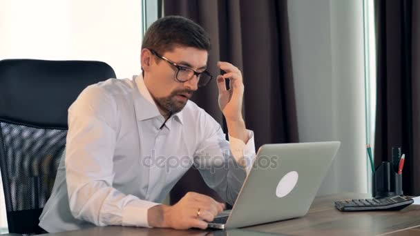 Een zakenman typt op een laptop en zuchten. — Stockvideo