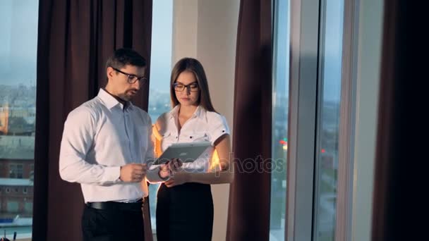 Un hombre de negocios muestra su proyecto en una tableta a una mujer . — Vídeos de Stock