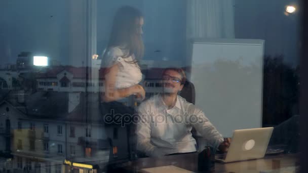 Um homem de negócios e uma mulher de negócios refletem sobre a janela de vidro . — Vídeo de Stock