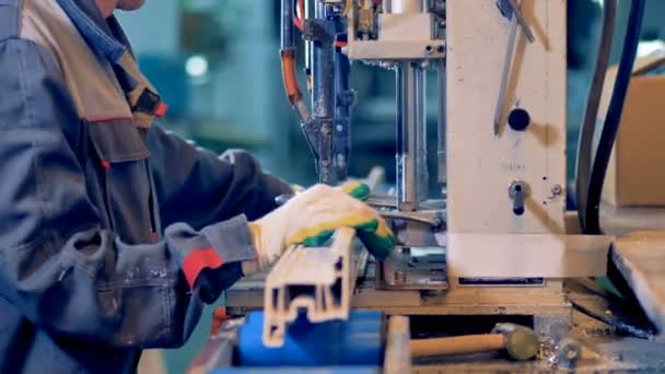 Arbeiter bearbeitet Kunststoff-Detail an Industriemaschine. — Stockvideo