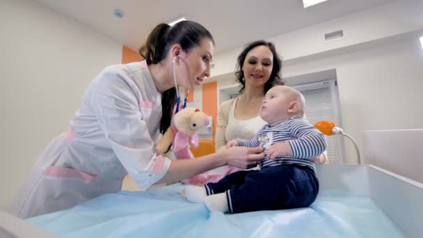 Un médico usa su estetoscopio en un niño pequeño . — Vídeo de stock