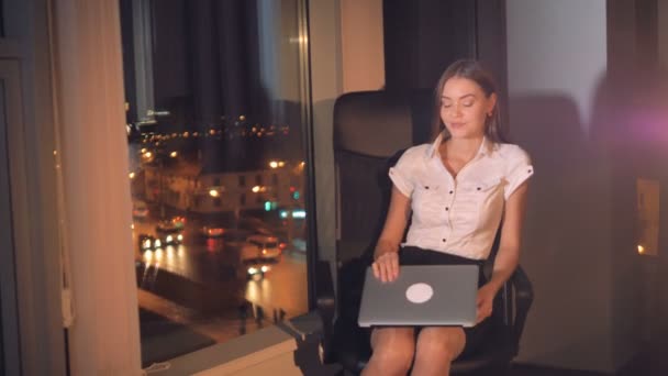 Affärskvinna fungerar på en laptop nära ett fönster i office. — Stockvideo