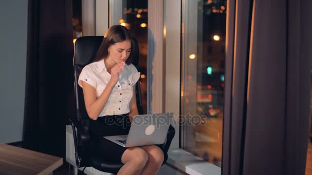 Affärskvinna slutar skriva på en bärbar dator på grund av sena timme. — Stockvideo
