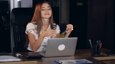 Gözlüklerini bir laptop kapalı bir iş kadını alır.