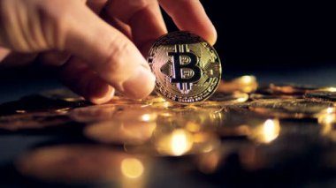 Bir insan eli birçok altın bitcoins gösterir.