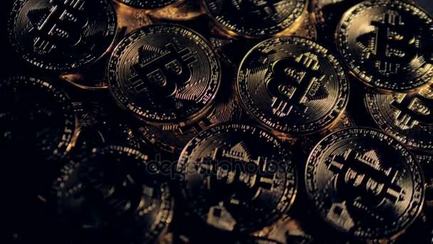 Viele goldene Bitcoins liegen im schummrigen Licht. — Stockvideo