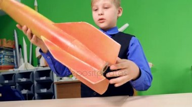 Bir çocuk okulda bir uzay roket modeli yapma