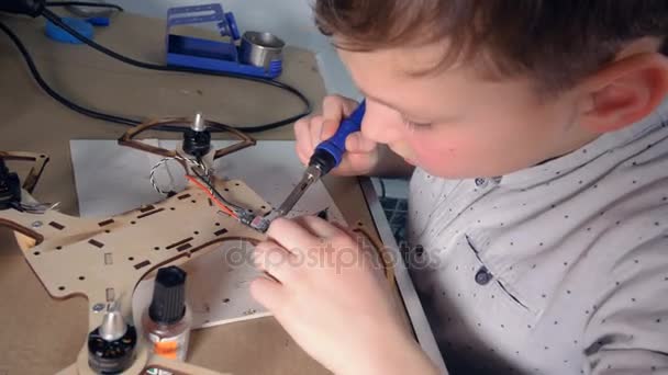 Ein Kind arbeitet an seinem modernen Fluggerät — Stockvideo