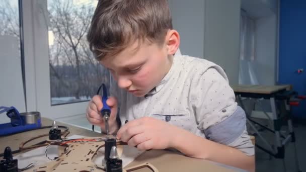 Un ragazzino sta saldando il suo moderno gadget volante — Video Stock