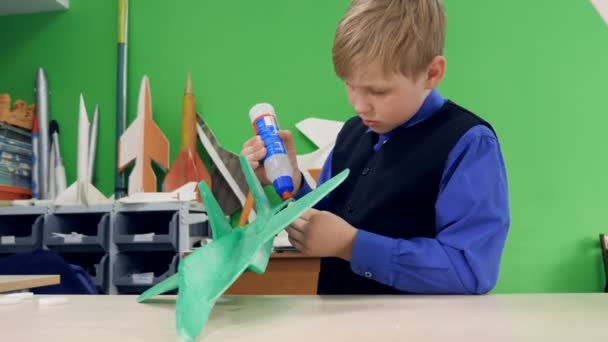 Un niño está construyendo su propio avión. — Vídeo de stock