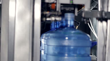 Açılan ve etiketli 5 galon şişe su.