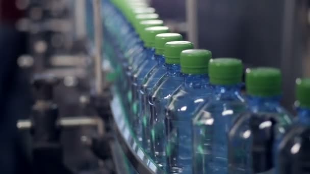 Un convoyeur à déplacement lent avec des bouteilles en PET prêtes pour l'étiquetage . — Video