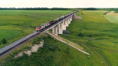 Bir yük treni bir demiryolu köprü üstünden geçiyor..