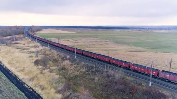 Una cámara aérea sigue un tren de mercancías con carbón en movimiento . — Vídeo de stock
