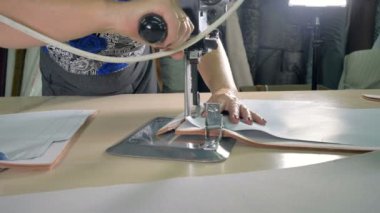Bir kadın işçi fazla kumaş keser.