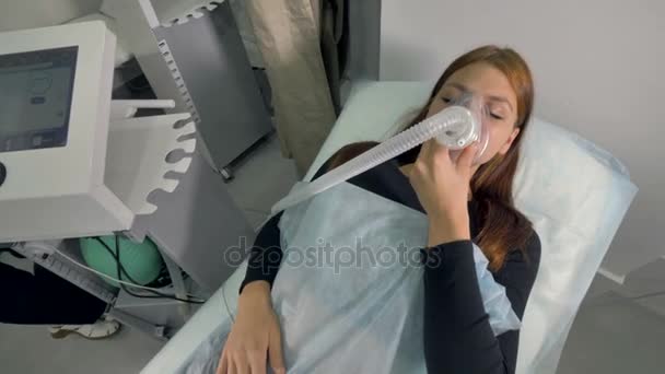 Жінка лежить з кисневою маскою під медичним наглядом . — стокове відео