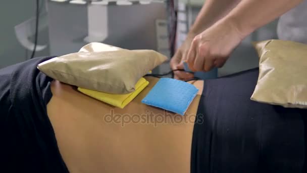 의사는 환자 뒤에 물리 치료 도포를 적용. — 비디오