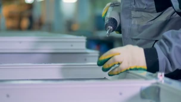 Travailleur industriel fixe des raccords métalliques sur un cadre de fenêtre . — Video