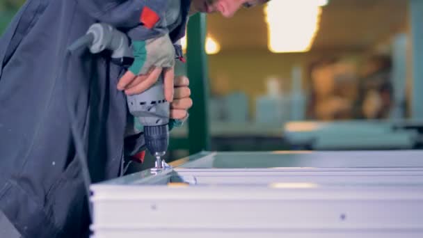 Człowiek, montaż plastikowych elementów za pomocą przemysłowych śrubokręt. — Wideo stockowe