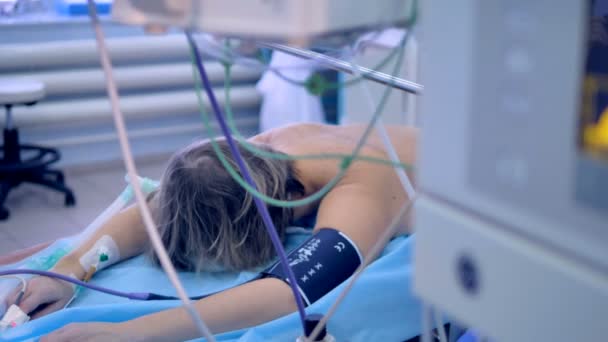 Een patiënt ligt gezicht naar beneden op een kinderbed tijdens medische procedure. — Stockvideo