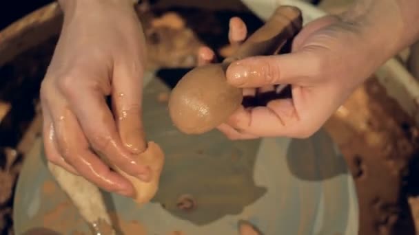 Un potier recouvre d'eau une cuillère d'argile . — Video