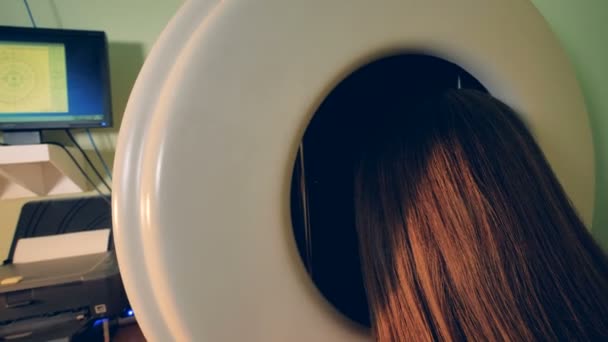 A long haired woman sits for an exam on an ophthalmic perimeter. — Stock Video