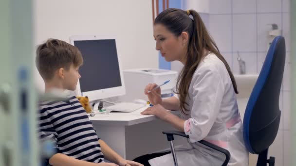 Amistoso médico escribe prescripción para niño . — Vídeo de stock