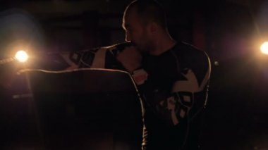 Gölgeli bir savaşçı yaptığı yumruk pratik bir yan görünüm.