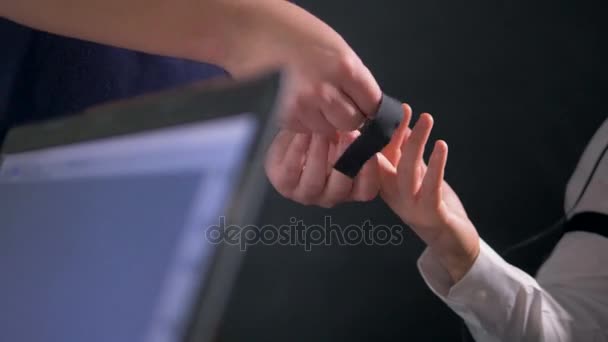 Un opérateur fixe une électrode sur le doigt d'un sujet . — Video