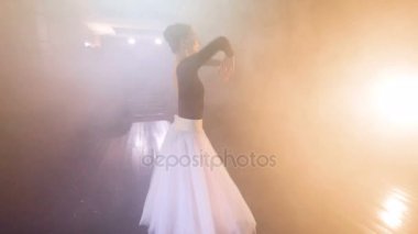 Bir balerin kollarını kafasının koyar..