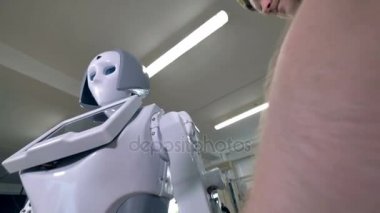 Bir mühendis robotlar kolundaki beyaz kabuk ekler.
