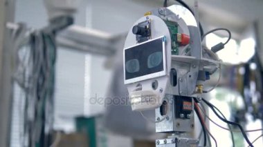 Gözleri yanıp sönen bir çalışma ekran gösteren robotlar kafayla.