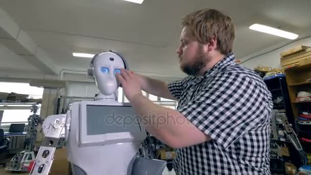 En serviceman monterar robotar huvudet täcker. — Stockvideo