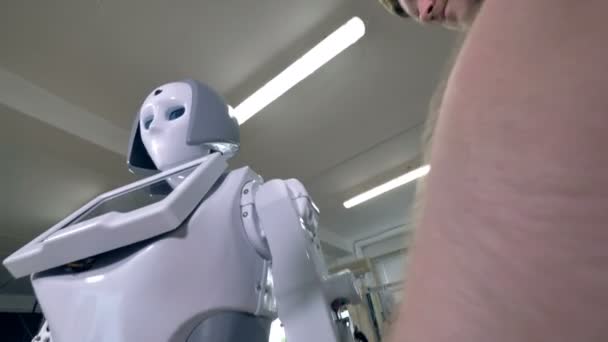 Un ingegnere attacca guscio bianco sul braccio robot . — Video Stock