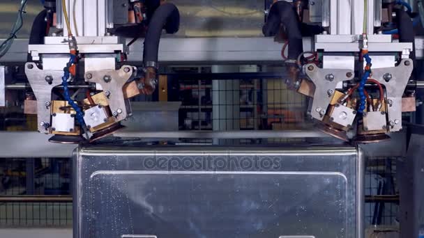 Ένα πλαίσιο χάλυβα γυρίζει μέσα σε μια ρομποτική μηχανή κατά τη διάρκεια της διαδικασίας συγκόλλησης. 4k. — Αρχείο Βίντεο