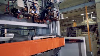 Aracı kafaları değişen bir robot çelik işleme makine üzerinde yan görünüm.