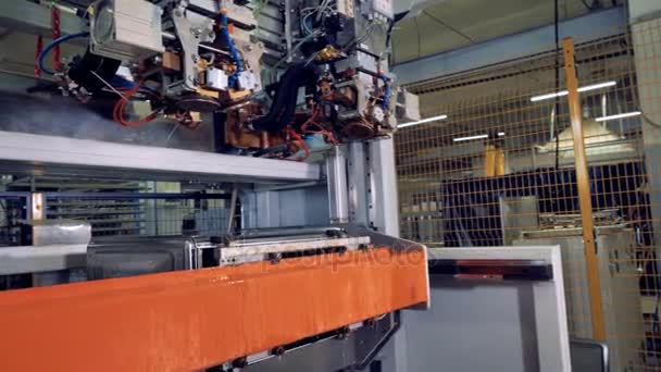 Una vista lateral de una máquina de procesamiento de acero robótica con cabezales de herramientas cambiantes . — Vídeo de stock