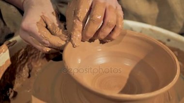 Potters eller üstünde a tekerlek bir kase bir kenarını oluşturur.