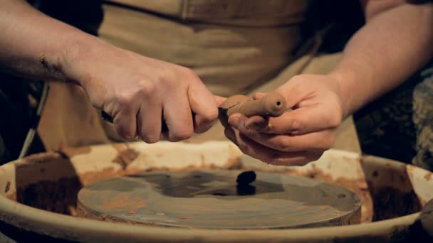 Горшечник отрезает лишнюю глину от заготовки ложки . — стоковое видео
