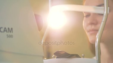 Bir kadının kafasını sıkıca göz testi önce konumlandırır.