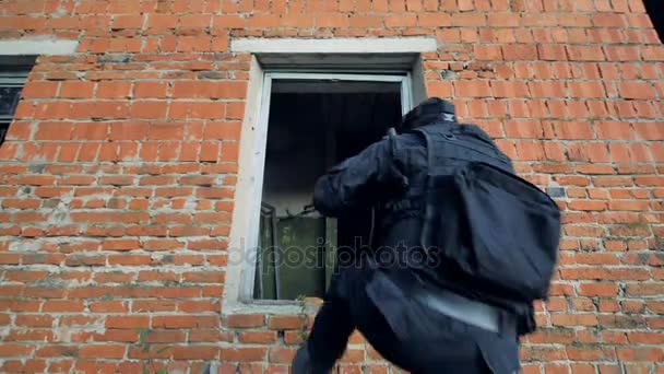 Miembros de la unidad especial entran en un edificio sospechoso a través de una ventana rota . — Vídeo de stock