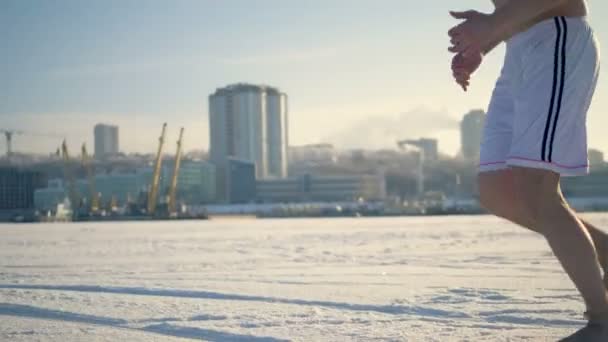 Mann läuft barfuß auf einem zugefrorenen Fluss. — Stockvideo