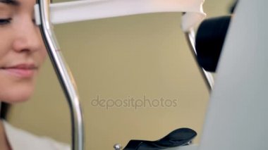 Bir kadın tıbbi malzeme destekler bir göz muayenesi önce kafasını yerleştirir. 4k.