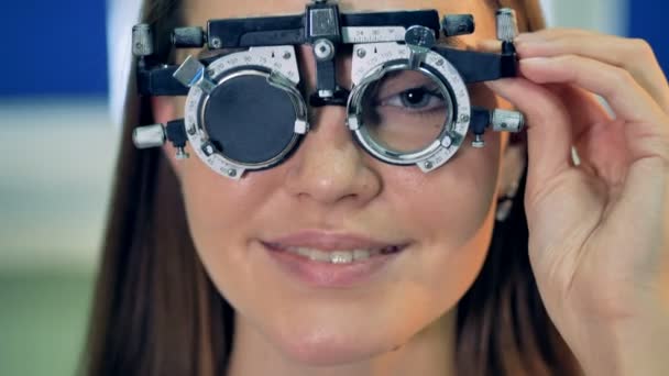 Una mujer joven sostiene un marco de prueba durante el reemplazo de lentes . — Vídeos de Stock
