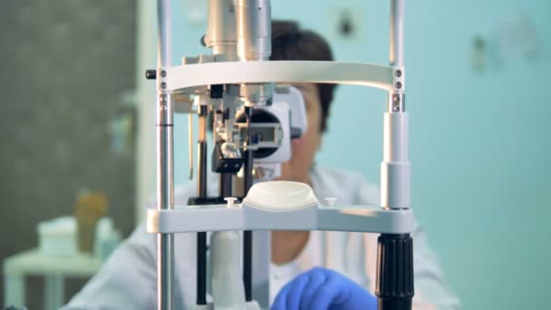 Un oftalmólogo mueve las partes internas de una lámpara de hendidura . — Vídeo de stock