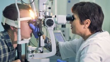 Adam göz yaralanmaları için ofisinde bir göz doktoruna denetler.