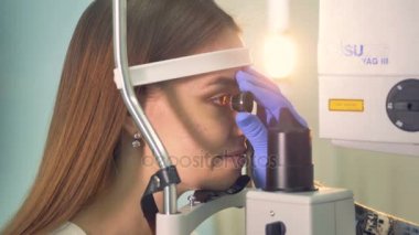 Bir doktor bir womans göz yakın müstakil bir lens tutar.